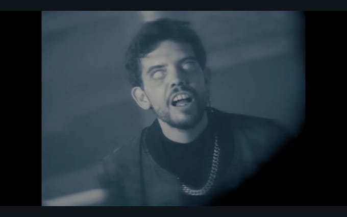 Primer plano del actor Javier Bódalo con ojos blancos en el videoclip oficial 100 Rosas y 1 Puñal de Uña y Carne